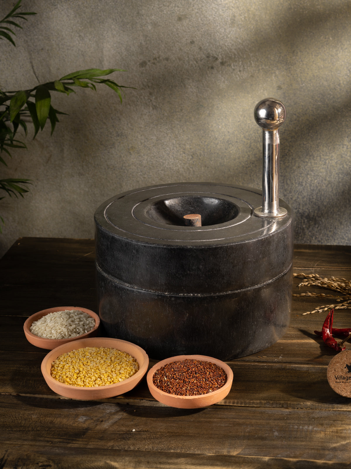 Traditional Handmade Atta Chakki placed on table surrounded by fresh ingredients.