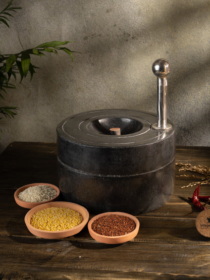 Traditional Handmade Atta Chakki placed on table surrounded by fresh ingredients.