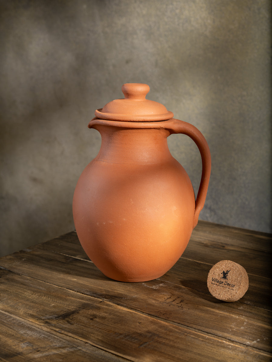 Handmade clay water Jug in traditional matka style by Village Decor, placed on a rustic wooden table.
