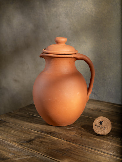 Handmade clay water Jug in traditional matka style by Village Decor, placed on a rustic wooden table.
