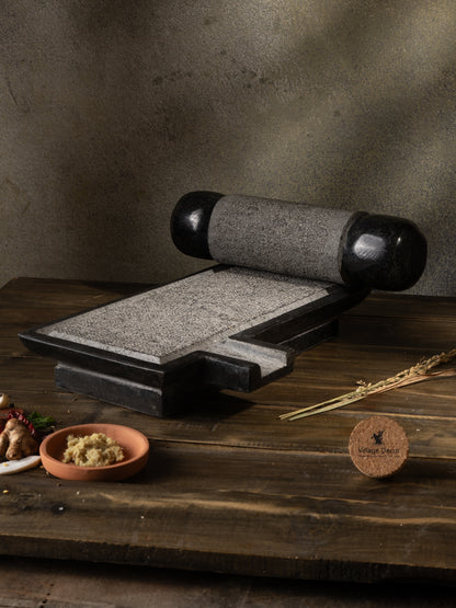 Traditional Handmade silbatta placed on table surrounded by fresh ingredients.