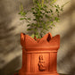 Handcrafted terracotta Tulsi Pot with Tulsi plant in traditional Vrindavan style, placed in a pooja setup with natural lighting and sacred decor.
