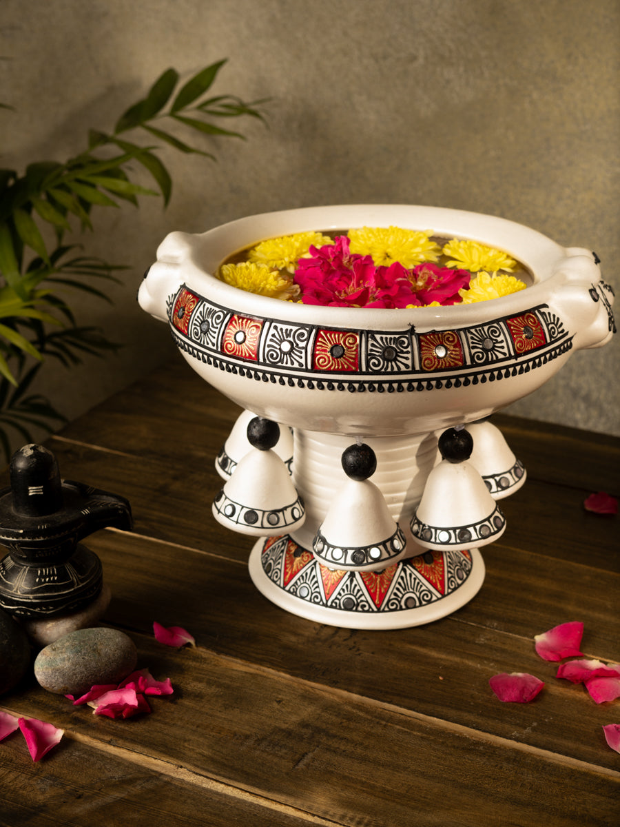 Handcrafted multicolor terracotta urli with floral design placed on a wooden surface, styled with rose petals and traditional decor for a festive look.
