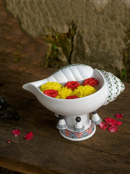 Decorative white  sangu urli colorful flowers on a wooden surface