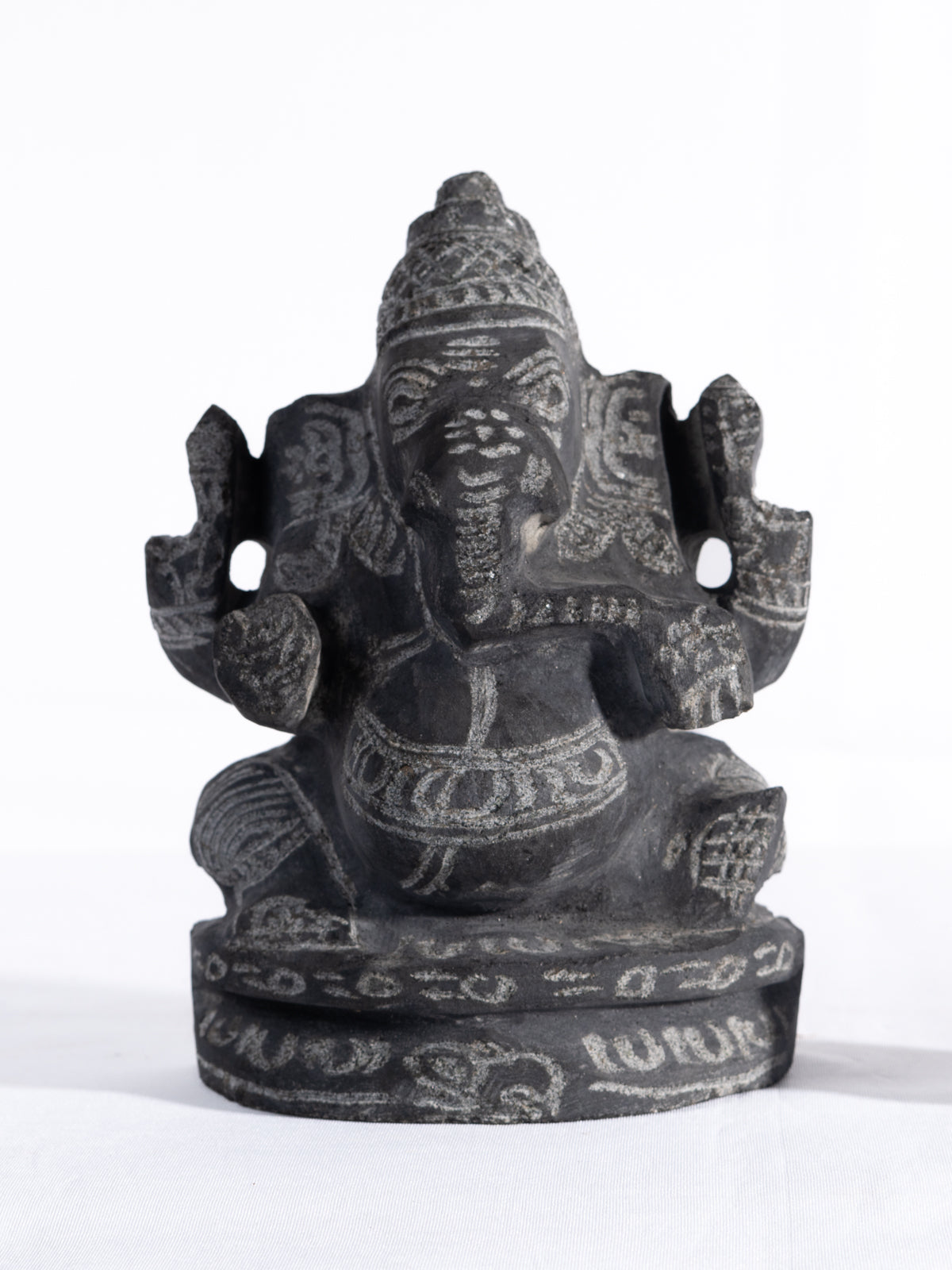 Black stone Vinayagar idol white background view handcrafted Ganesha statue for home decor vastu and spiritual placement.
